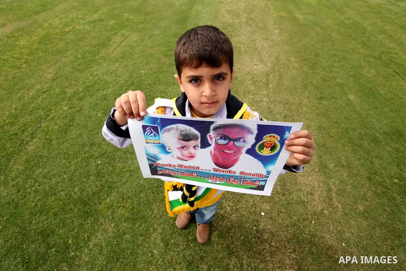 Palestinian chlidren hold ballons and posters bearing a portrait of Palestinian boy Ahmed Dawabsha, 5, who suffered severe burns in an arson attack by suspected Jewish attackers on his family home last July and in which...