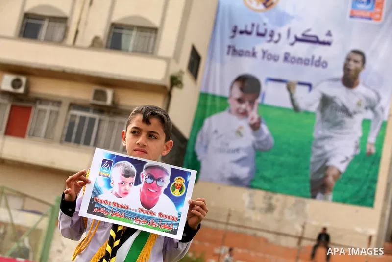 Palestinian chlidren hold ballons and posters bearing a portrait of Palestinian boy Ahmed Dawabsha, 5, who suffered severe burns in an arson attack by suspected Jewish attackers on his family home last July and in which...