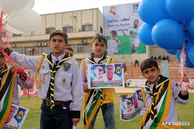 Palestinian chlidren hold ballons and posters bearing a portrait of Palestinian boy Ahmed Dawabsha, 5, who suffered severe burns in an arson attack by suspected Jewish attackers on his family home last July and in which...