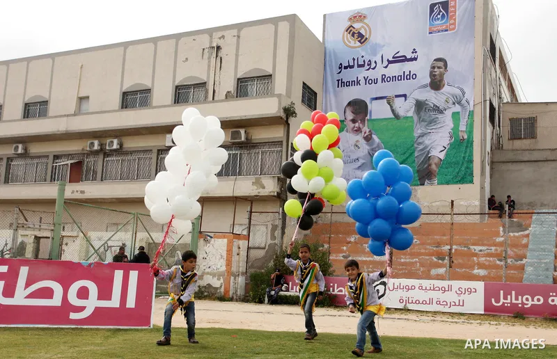 Palestinian chlidren hold ballons and posters bearing a portrait of Palestinian boy Ahmed Dawabsha, 5, who suffered severe burns in an arson attack by suspected Jewish attackers on his family home last July and in which...