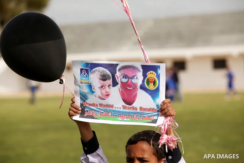 Palestinian chlidren hold ballons and posters bearing a portrait of Palestinian boy Ahmed Dawabsha, 5, who suffered severe burns in an arson attack by suspected Jewish attackers on his family home last July and in which...