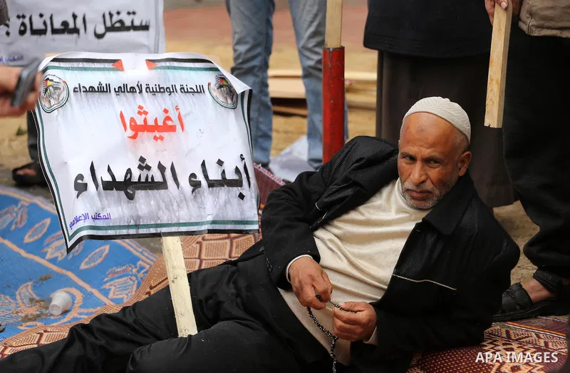Palestinian families of martyrs, hold banners during a protest to demand their salaries, in front of Red cross office, in Gaza city, on March 28, 2016. Photo by Mohammed Asad