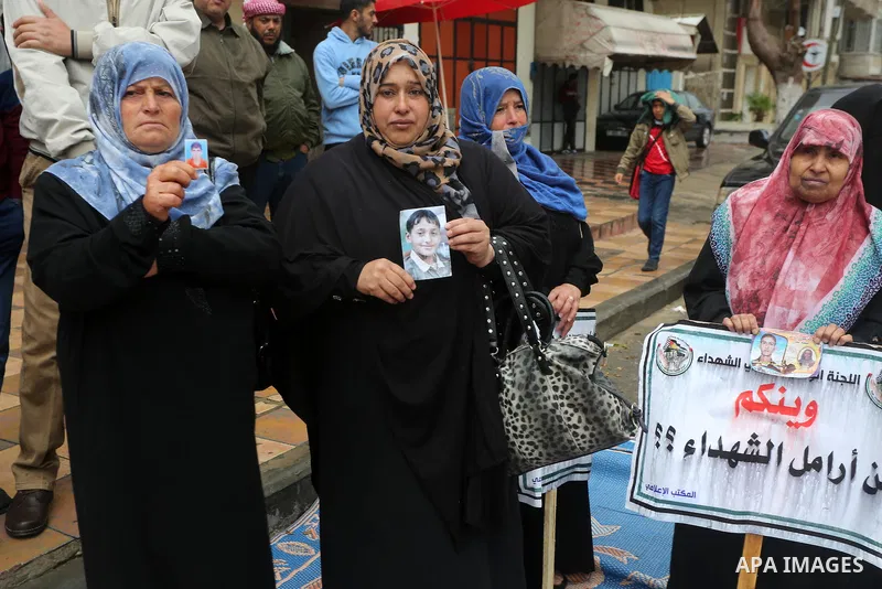 Palestinian families of martyrs, hold banners during a protest to demand their salaries, in front of Red cross office, in Gaza city, on March 28, 2016. Photo by Mohammed Asad