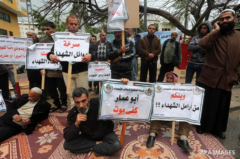 Palestinian families of martyrs, hold banners during a protest to demand their salaries, in front of Red cross office, in Gaza city, on March 28, 2016. Photo by Mohammed Asad