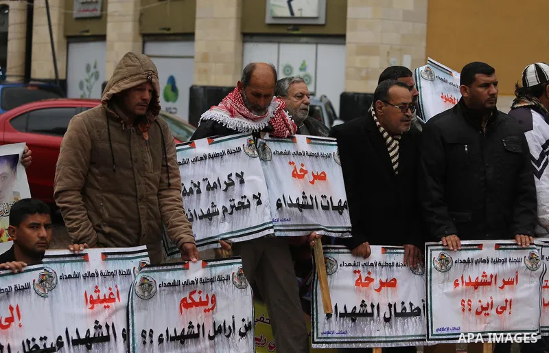 Palestinian families of martyrs, hold banners during a protest to demand their salaries, in front of Red cross office, in Gaza city, on March 28, 2016. Photo by Mohammed Asad