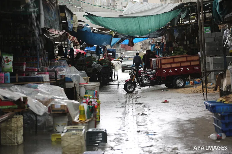 Palestinians walk in a flooded street during a rainy day, in Gaza city, on March 28, 2016. Photo by Mohammed Asad