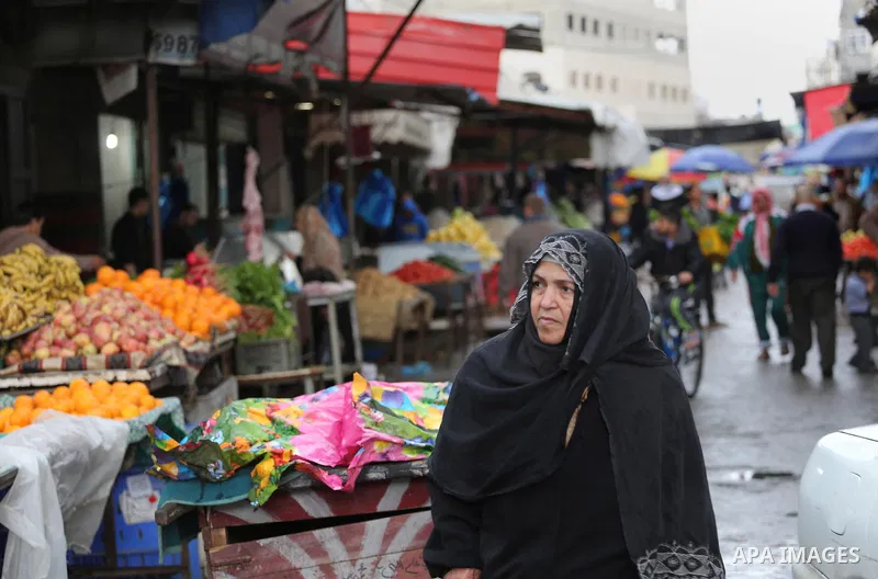 Palestinians walk in a flooded street during a rainy day, in Gaza city, on March 28, 2016. Photo by Mohammed Asad