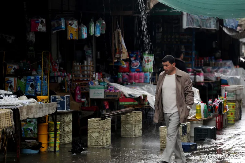 Palestinians walk in a flooded street during a rainy day, in Gaza city, on March 28, 2016. Photo by Mohammed Asad
