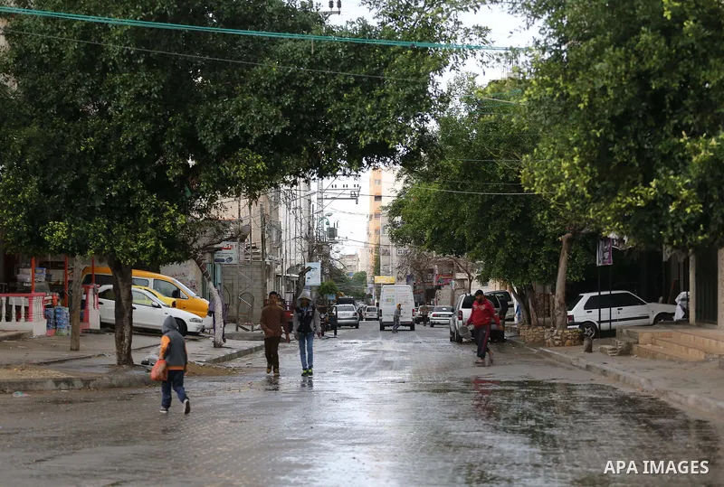 Palestinians walk in a flooded street during a rainy day, in Gaza city, on March 28, 2016. Photo by Mohammed Asad