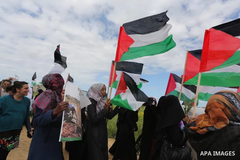 Palestinians hold national flags during a march to mark Land Day in Gaza, on March 29, 2016. The annual demonstrations mark the deaths of six Arab Israeli protesters at the hands of Israeli police and troops during mass...