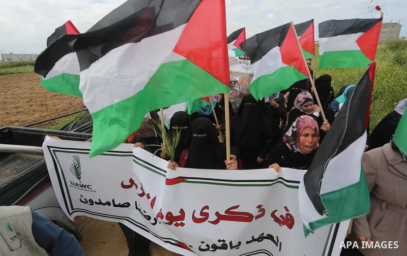 Palestinians hold national flags during a march to mark Land Day in Gaza, on March 29, 2016. The annual demonstrations mark the deaths of six Arab Israeli protesters at the hands of Israeli police and troops during mass...