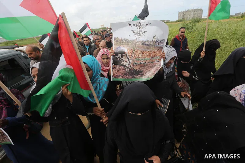 Palestinians hold national flags during a march to mark Land Day in Gaza, on March 29, 2016. The annual demonstrations mark the deaths of six Arab Israeli protesters at the hands of Israeli police and troops during mass...