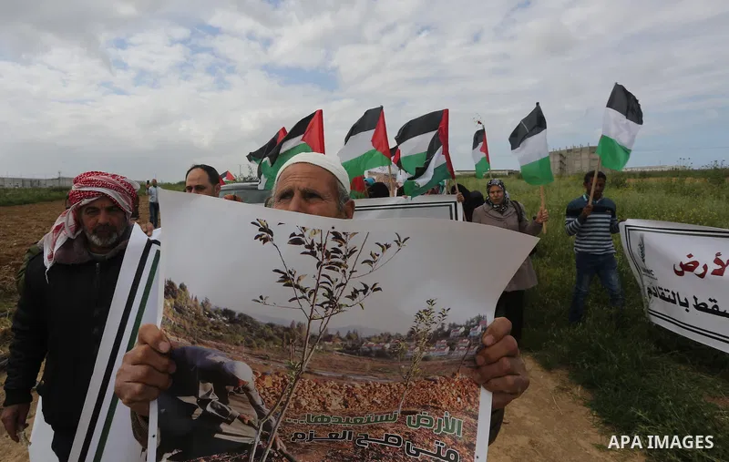 Palestinians hold national flags during a march to mark Land Day in Gaza, on March 29, 2016. The annual demonstrations mark the deaths of six Arab Israeli protesters at the hands of Israeli police and troops during mass...