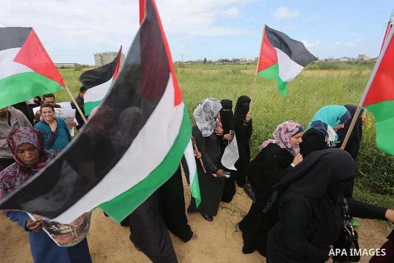 Palestinians hold national flags during a march to mark Land Day in Gaza, on March 29, 2016. The annual demonstrations mark the deaths of six Arab Israeli protesters at the hands of Israeli police and troops during mass...