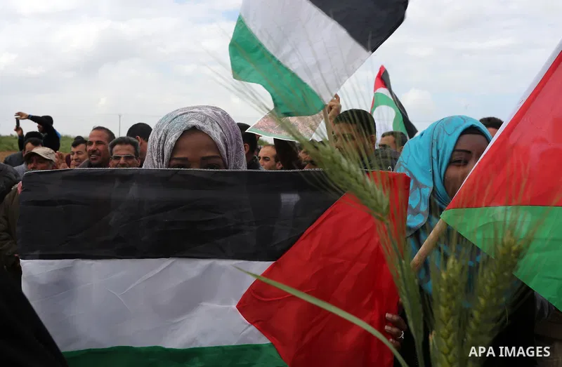 Palestinians hold national flags during a march to mark Land Day in Gaza, on March 29, 2016. The annual demonstrations mark the deaths of six Arab Israeli protesters at the hands of Israeli police and troops during mass...