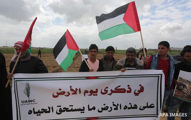 Palestinians hold national flags during a march to mark Land Day in Gaza, on March 29, 2016. The annual demonstrations mark the deaths of six Arab Israeli protesters at the hands of Israeli police and troops during mass...