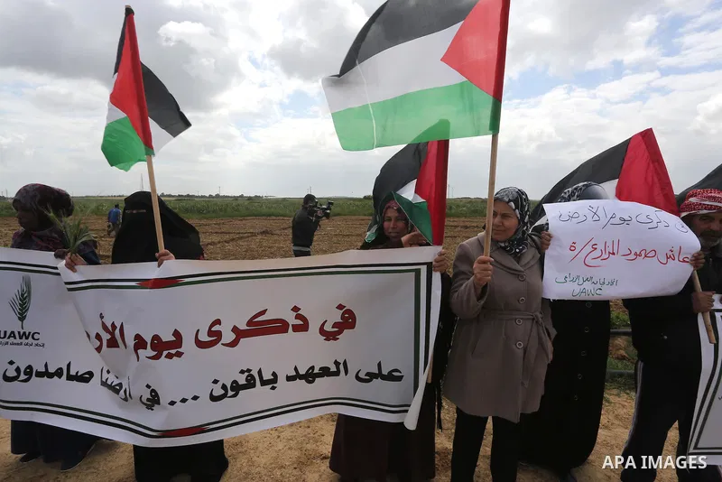 Palestinians hold national flags during a march to mark Land Day in Gaza, on March 29, 2016. The annual demonstrations mark the deaths of six Arab Israeli protesters at the hands of Israeli police and troops during mass...