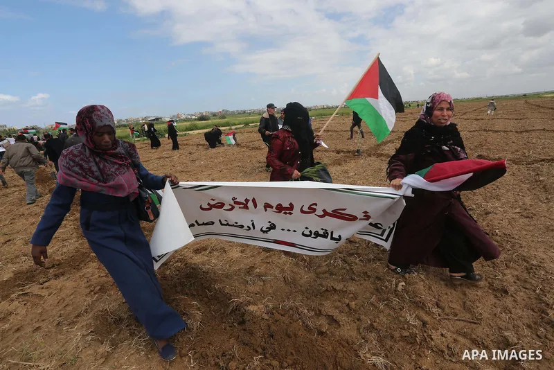 Palestinians hold national flags during a march to mark Land Day in Gaza, on March 29, 2016. The annual demonstrations mark the deaths of six Arab Israeli protesters at the hands of Israeli police and troops during mass...