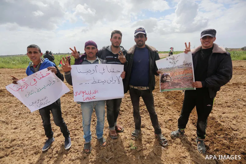 Palestinians hold national flags during a march to mark Land Day in Gaza, on March 29, 2016. The annual demonstrations mark the deaths of six Arab Israeli protesters at the hands of Israeli police and troops during mass...