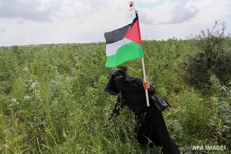 Palestinians hold national flags during a march to mark Land Day in Gaza, on March 29, 2016. The annual demonstrations mark the deaths of six Arab Israeli protesters at the hands of Israeli police and troops during mass...