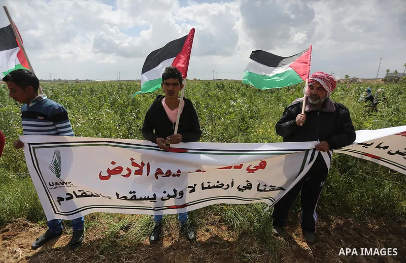 Palestinians hold national flags during a march to mark Land Day in Gaza, on March 29, 2016. The annual demonstrations mark the deaths of six Arab Israeli protesters at the hands of Israeli police and troops during mass...