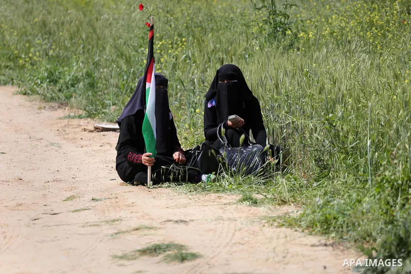 Palestinians hold national flags during a march to mark Land Day in Gaza, on March 29, 2016. The annual demonstrations mark the deaths of six Arab Israeli protesters at the hands of Israeli police and troops during mass...