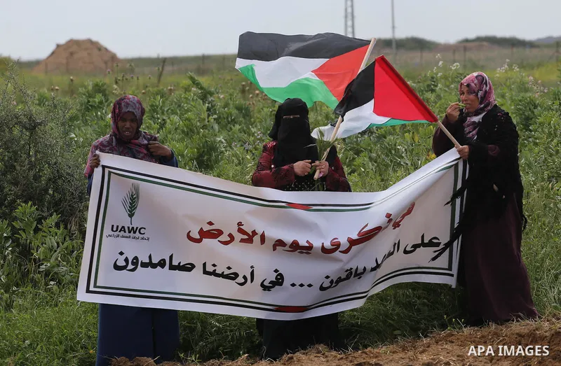 Palestinians hold national flags during a march to mark Land Day in Gaza, on March 29, 2016. The annual demonstrations mark the deaths of six Arab Israeli protesters at the hands of Israeli police and troops during mass...