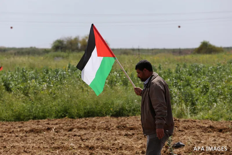 Palestinians hold national flags during a march to mark Land Day in Gaza, on March 29, 2016. The annual demonstrations mark the deaths of six Arab Israeli protesters at the hands of Israeli police and troops during mass...