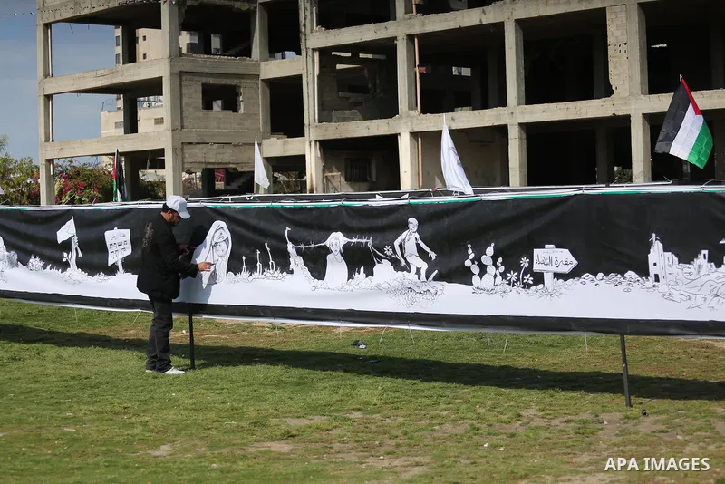 A Palestinian artist paints a mural during a rally marking Land Day, in Gaza City March 30, 2016. March 30 marks Land Day, the annual commemorations of the killing by police of six Arab citizens in 1976 during protests a...