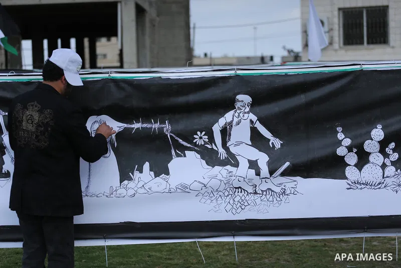 A Palestinian artist paints a mural during a rally marking Land Day, in Gaza City March 30, 2016. March 30 marks Land Day, the annual commemorations of the killing by police of six Arab citizens in 1976 during protests a...