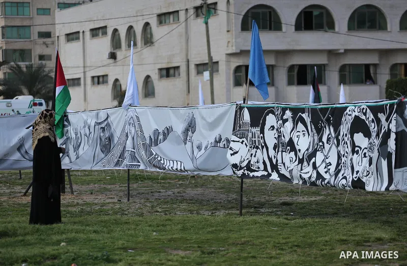 A Palestinian woman walks past a mural during a rally marking Land Day, in Gaza City March 30, 2016. March 30 marks Land Day, the annual commemorations of the killing by police of six Arab citizens in 1976 during protest...