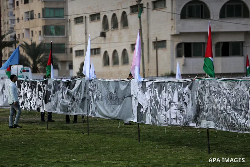 A Palestinian man walks past a mural during a rally marking Land Day, in Gaza City March 30, 2016. March 30 marks Land Day, the annual commemorations of the killing by police of six Arab citizens in 1976 during protests...