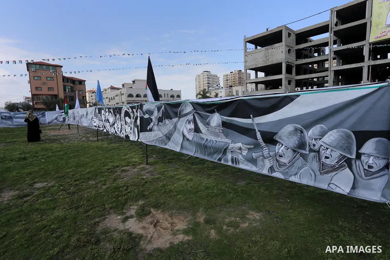 A Palestinian woman walks past a mural during a rally marking Land Day, in Gaza City March 30, 2016. March 30 marks Land Day, the annual commemorations of the killing by police of six Arab citizens in 1976 during protest...