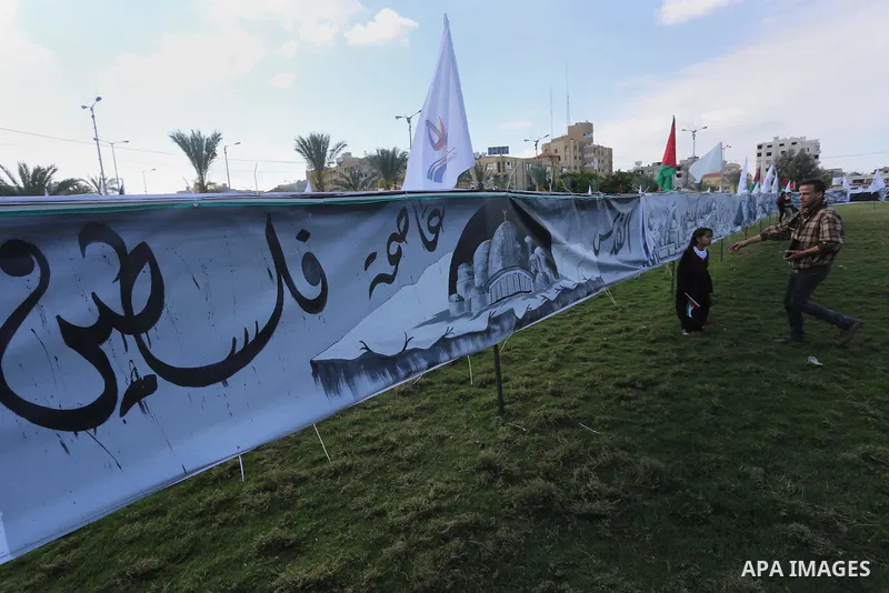 Palestinians walk past a mural during a rally marking Land Day, in Gaza City March 30, 2016. March 30 marks Land Day, the annual commemorations of the killing by police of six Arab citizens in 1976 during protests agains...