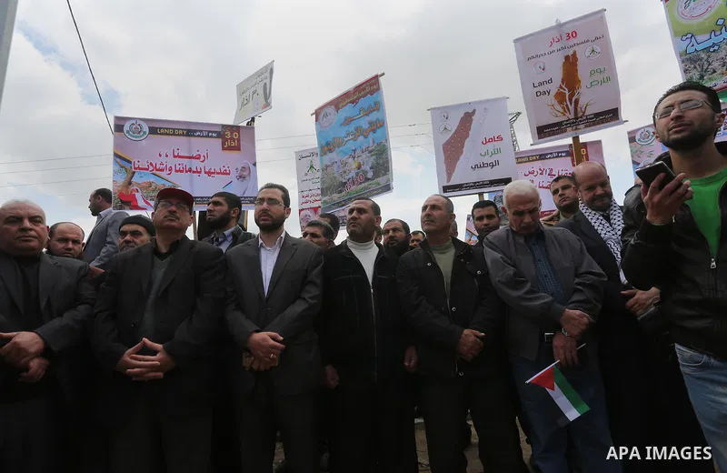 Palestinians hold banners and Palestine flags during a rally marking Land Day, near the Israeli border with northern Gaza Strip March 30, 2016. March 30 marks Land Day, the annual commemorations of the killing by police...