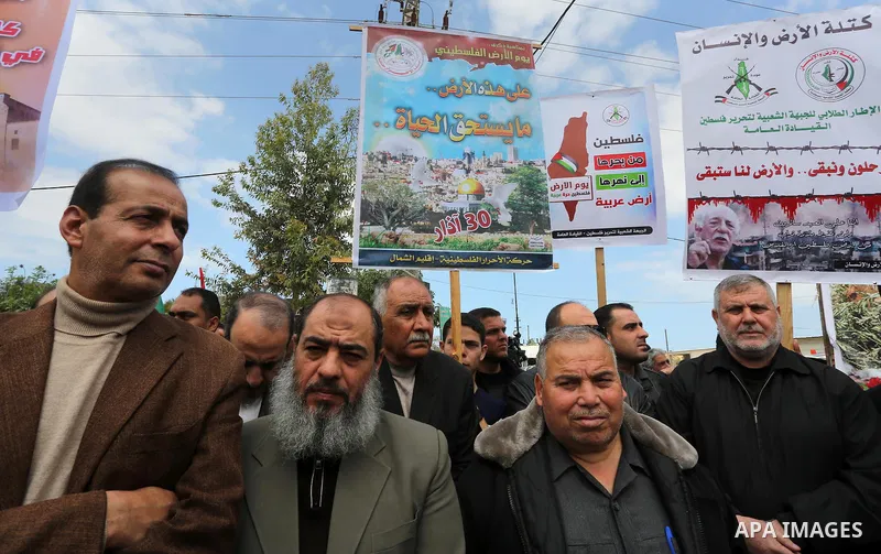 Palestinians hold banners and Palestine flags during a rally marking Land Day, near the Israeli border with northern Gaza Strip March 30, 2016. March 30 marks Land Day, the annual commemorations of the killing by police...