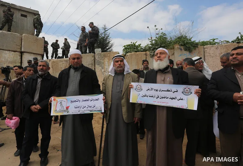 Palestinians hold banners and Palestine flags during a rally marking Land Day, near the Israeli border with northern Gaza Strip March 30, 2016. March 30 marks Land Day, the annual commemorations of the killing by police...