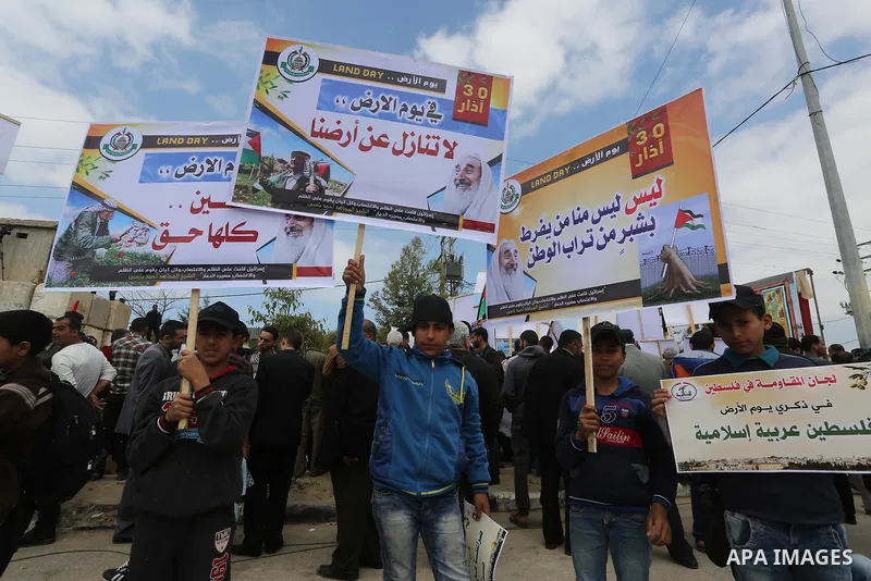 Palestinians hold banners and Palestine flags during a rally marking Land Day, near the Israeli border with northern Gaza Strip March 30, 2016. March 30 marks Land Day, the annual commemorations of the killing by police...