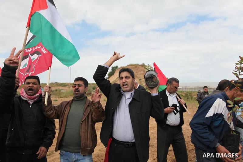 Demonstrators holding Palestinian flags chant slogans during a rally marking Land Day, near the Israeli border with central Gaza Strip March 30, 2016. March 30 marks Land Day, the annual commemorations of the killing by...