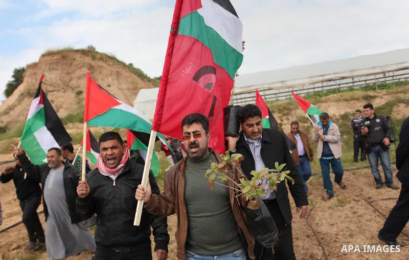 Demonstrators holding Palestinian flags chant slogans during a rally marking Land Day, near the Israeli border with central Gaza Strip March 30, 2016. March 30 marks Land Day, the annual commemorations of the killing by...