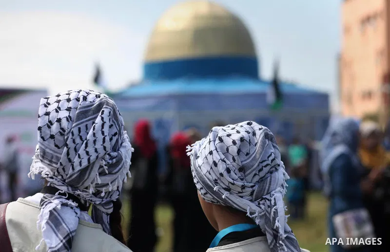 Palestinians walk past a model depicting the Dome of the Rock during a rally marking Land Day, in Gaza City March 30, 2016. March 30 marks Land Day, the annual commemorations of the killing by police of six Arab citizens...