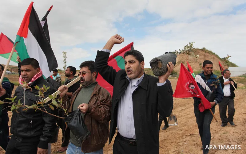 Demonstrators holding Palestinian flags chant slogans during a rally marking Land Day, near the Israeli border with central Gaza Strip March 30, 2016. March 30 marks Land Day, the annual commemorations of the killing by...