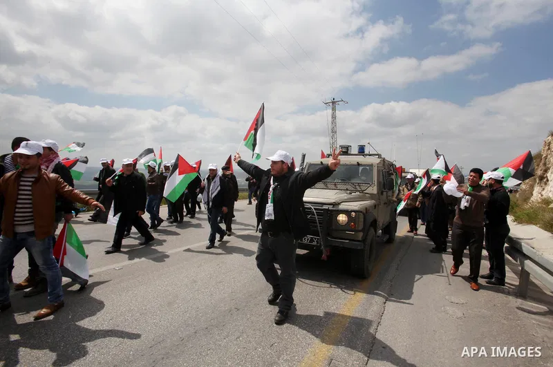 Palestinian demonstrators hold Palestinian flags during a rally marking Land Day in the West Bank village of Burqa near Nablus on March 30, 2016. March 30 marks Land Day, the annual commemorations of the killing by polic...