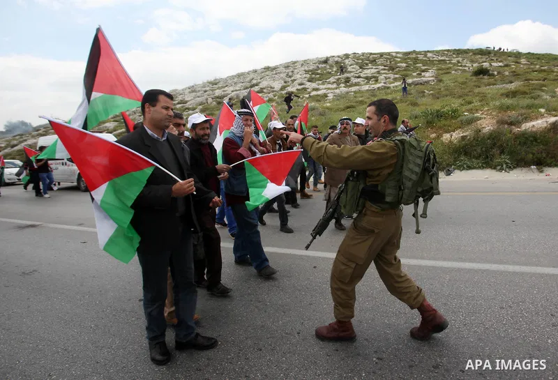 Palestinian demonstrators hold Palestinian flags during a rally marking Land Day in the West Bank village of Burqa near Nablus on March 30, 2016. March 30 marks Land Day, the annual commemorations of the killing by polic...