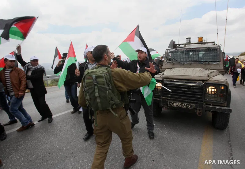Palestinian demonstrators hold Palestinian flags during a rally marking Land Day in the West Bank village of Burqa near Nablus on March 30, 2016. March 30 marks Land Day, the annual commemorations of the killing by polic...