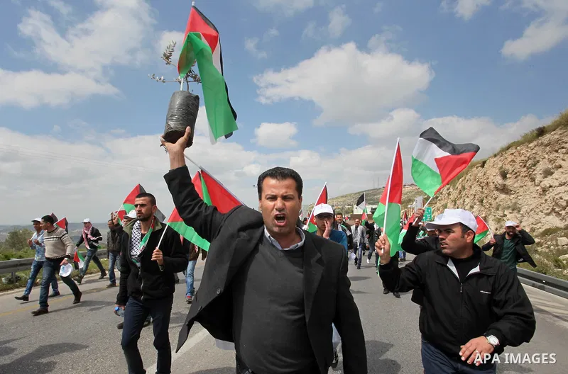Palestinian demonstrators hold Palestinian flags during a rally marking Land Day in the West Bank village of Burqa near Nablus on March 30, 2016. March 30 marks Land Day, the annual commemorations of the killing by polic...