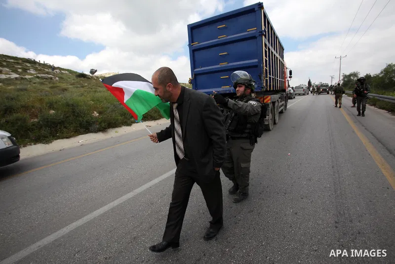 Palestinian demonstrators hold Palestinian flags during a rally marking Land Day in the West Bank village of Burqa near Nablus on March 30, 2016. March 30 marks Land Day, the annual commemorations of the killing by polic...