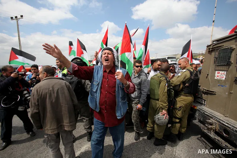 Palestinian demonstrators hold Palestinian flags during a rally marking Land Day in the West Bank village of Burqa near Nablus on March 30, 2016. March 30 marks Land Day, the annual commemorations of the killing by polic...