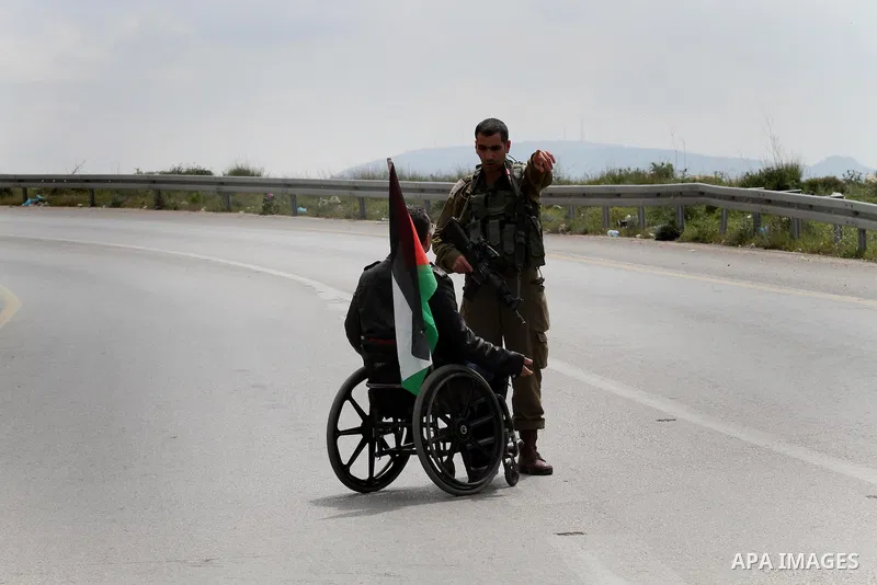 A Palestinian disabled argues with Israeli security forces during clashes following a rally marking Land Day in the West Bank village of Burqa near Nablus on March 30, 2016. March 30 marks Land Day, the annual commemorat...