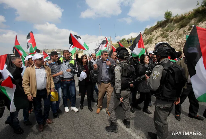 Palestinian demonstrators hold Palestinian flags during a rally marking Land Day in the West Bank village of Burqa near Nablus on March 30, 2016. March 30 marks Land Day, the annual commemorations of the killing by polic...